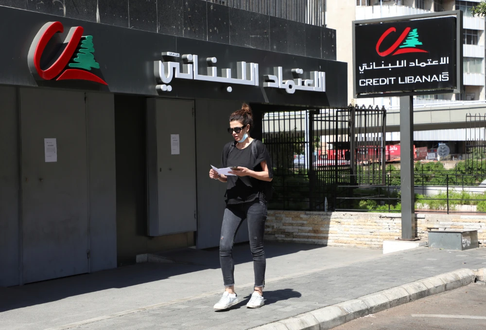 A woman walks past a closed branch of Credit Libanais bank in Beirut, Lebanon. (Reuters)