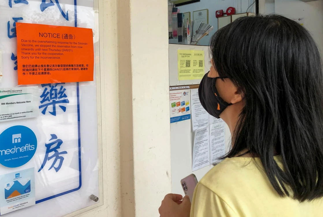 A woman reads a notice sign about ‘overwhelming response’ for the Sinovac COVID-19 vaccine at a clinic in Singapore June 18, 2021. (Reuters)