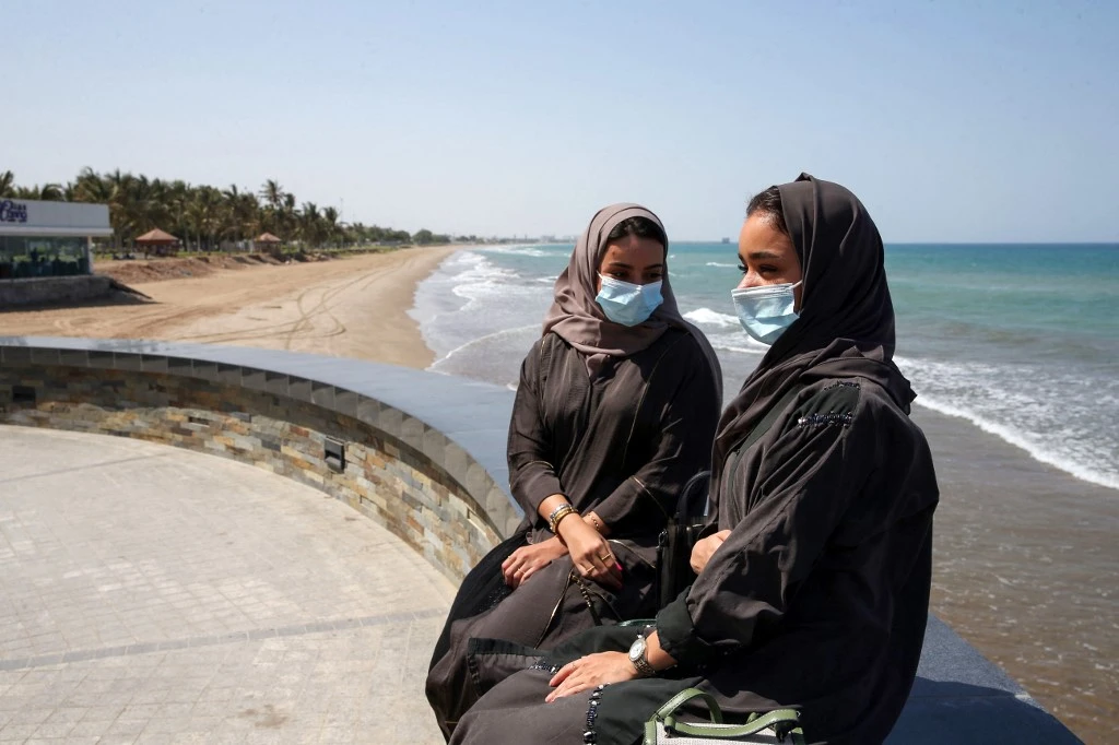 Omanis, wearing protective face masks, sit on the corniche in the capital Muscat on Oct. 12, 2020, during the coronavirus pandemic. (File/AFP)