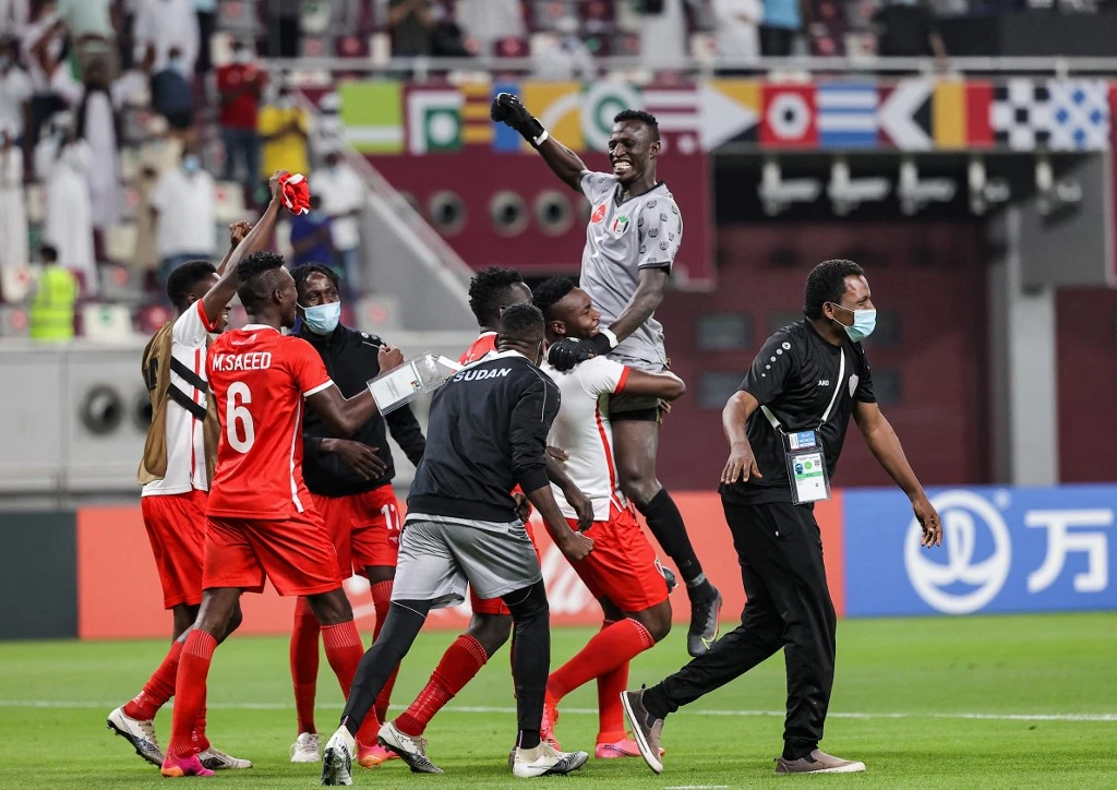 Sudan players celebrate after winning the 2021 FIFA Arab Cup qualifying match between Libya and Sudan at Khalifah International Stadium in Doha, Qatar on June 19, 2021. (AFP)