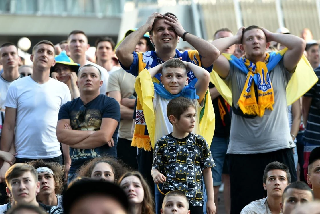 Ukrainian supporters react as they watch the EURO 2020 match between Ukraine and Austria on a giant screen of the fanzone in Kiev on Monday. (AFP)