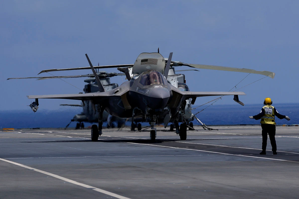 A crew member makes a signal to F-35 aircraft for take off on the UK's aircraft carrier HMS Queen Elizabeth in the Mediterranean Sea on June 20, 2021. (AP Photo/Petros Karadjias)