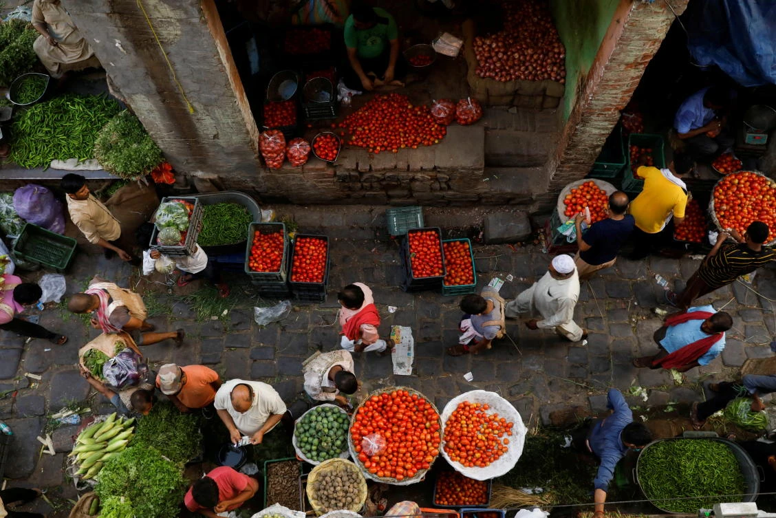 People shop at a crowded wholesale vegetable market in the old quarters of Delhi. Mideast oil exports to the country are shrinking as restrictions ease. (Reuters)