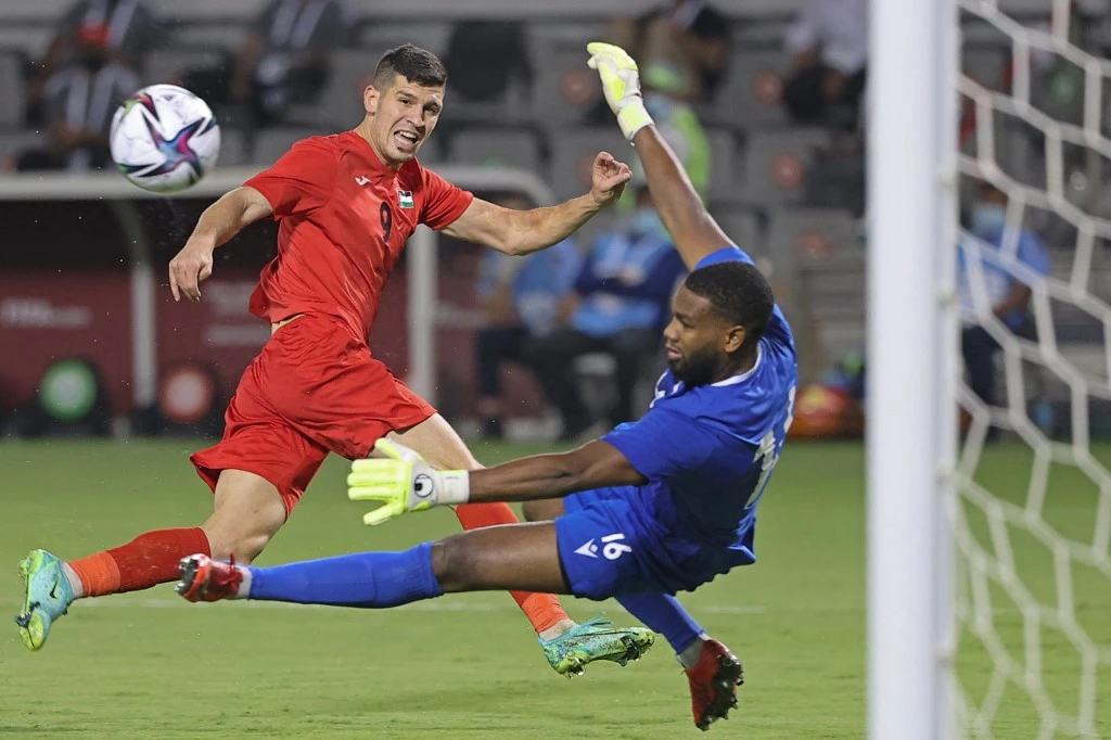 Palestine’s midfielder Tamer Seyam scores a goal past Comoros goalkeeper Moyadh Ousseni during the 2021 FIFA Arab Cup qualifier match in Doha, on June 24, 2021. (AFP)