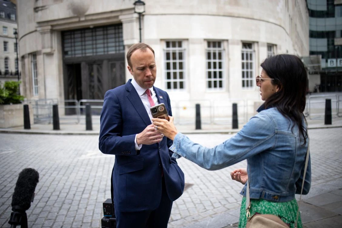 Britain’s Health Secretary Matt Hancock check his aide Gina Coladangelo’s phone outside BBC in central London on June 6. A British newspaper reported Friday that Hancock has been having an affair with Coladangelo. (AFP)