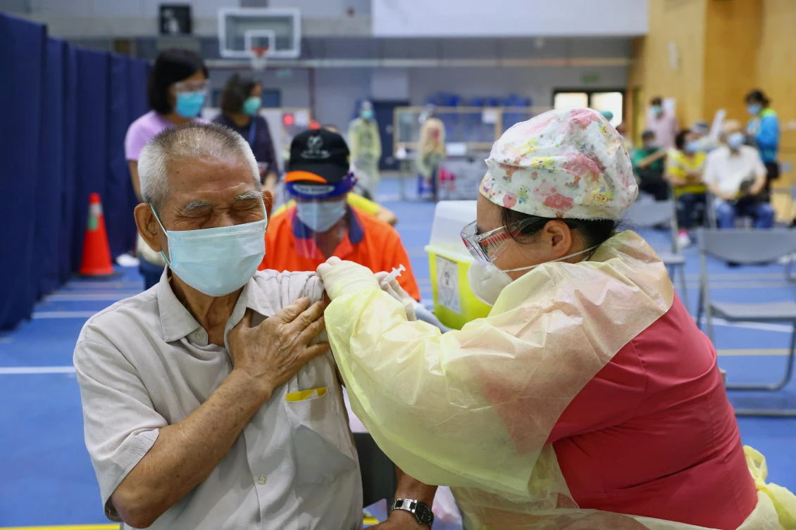 A medical worker administers a dose of the AstraZeneca vaccine against the coronavirus disease to a man in Taipei. (Reuters)