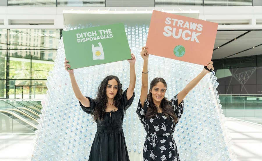 Artist Nourie Flayhan (L) holding up a sign that reads “Ditch the disposables.” Supplied