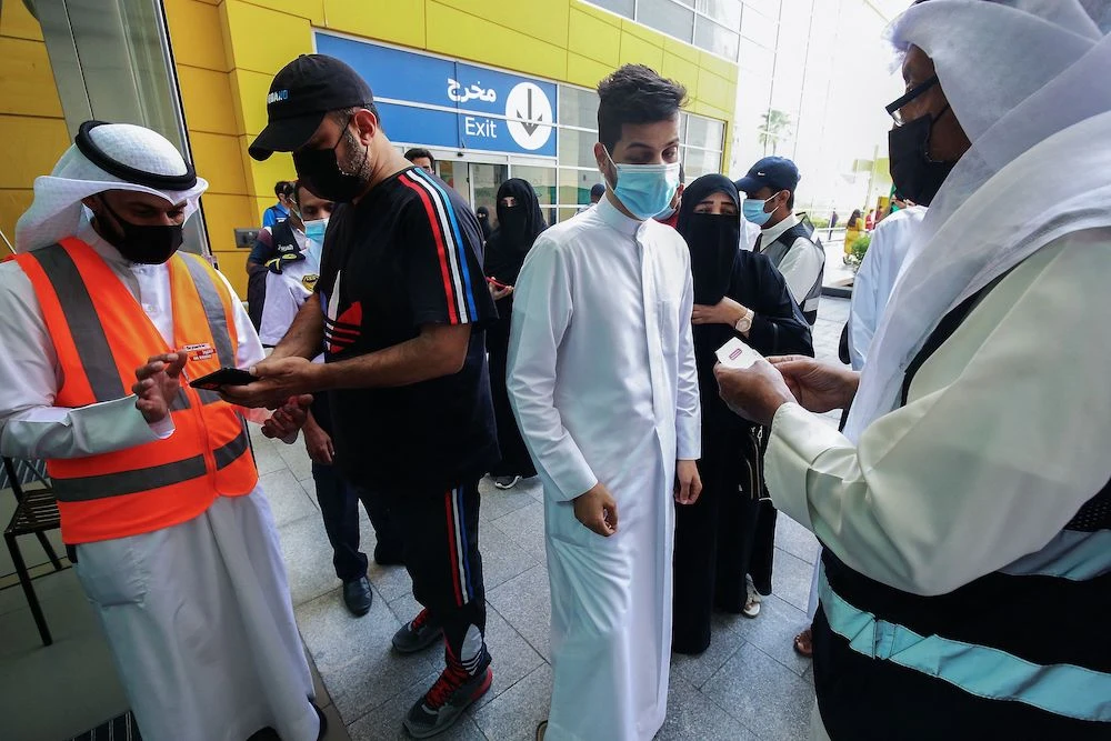 Kuwaitis queue as officials verify their vaccination certificates before allowing entry to The Avenues Mall in Kuwait City, the largest mall in the coutry, on June 27, 2021. (AFP)