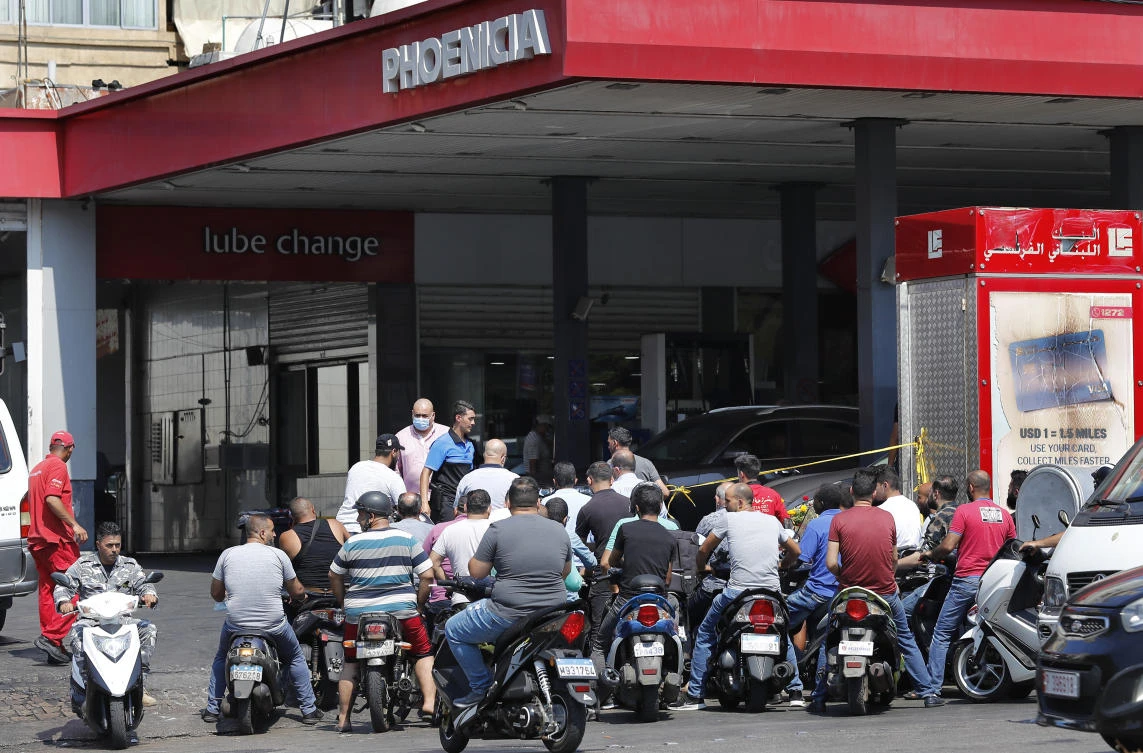 People on their scooters and motorcycles wait in queue for gasoline in Beirut. (AP)