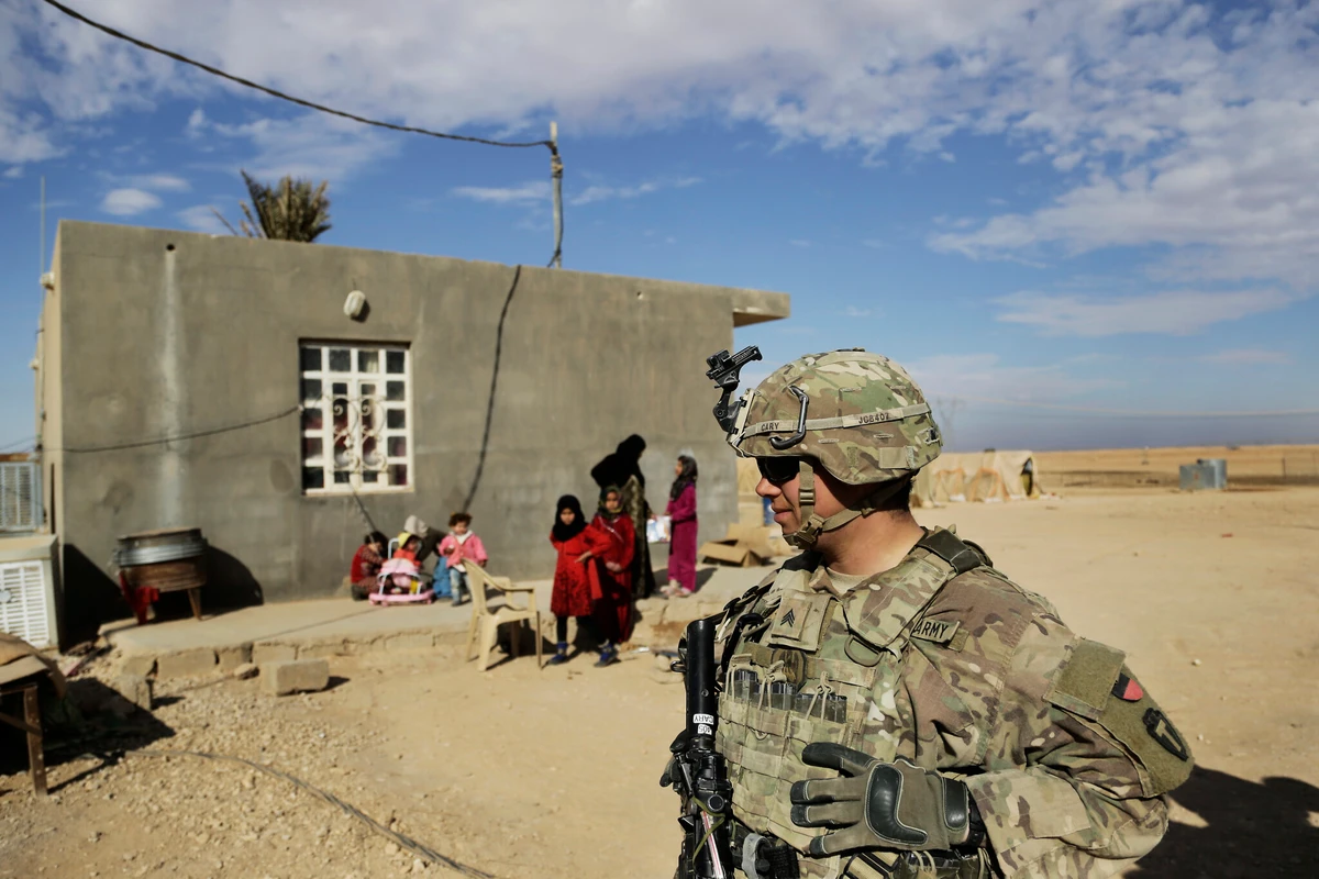 U.S. Army soldiers, on a reconnaissance patrol, speak to families in Anbar province, western Iraq, January 27, 2018. (AP Photo)