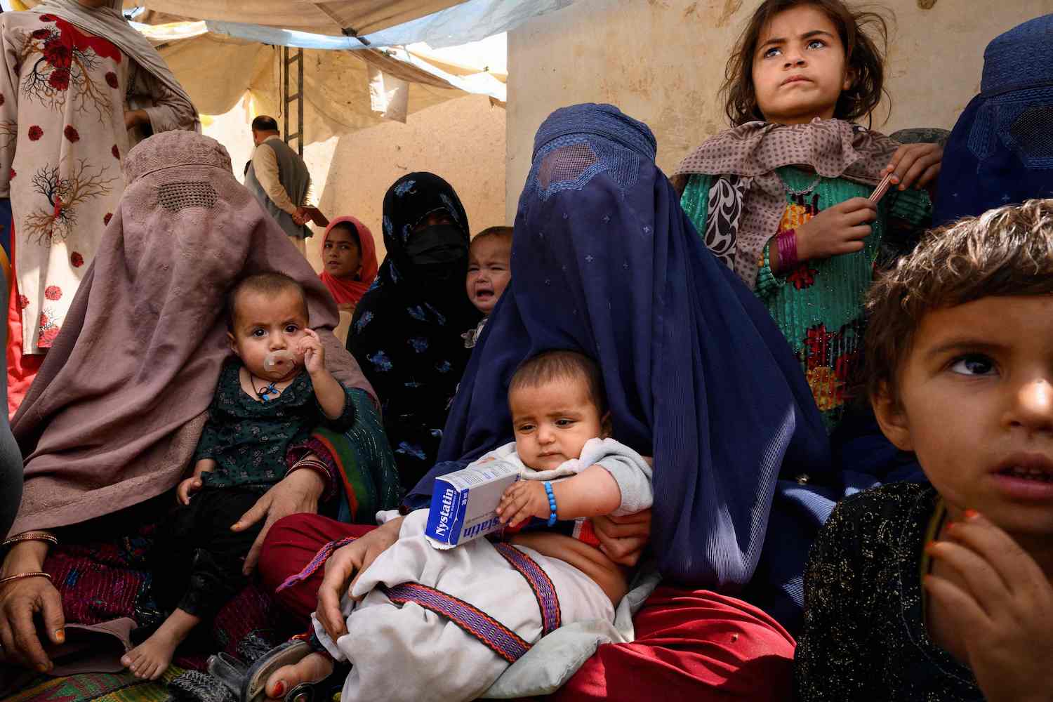 Women wait for their turn at a mobile clinic set up at the residence of a local elder in Helmand province. (File/AFP)