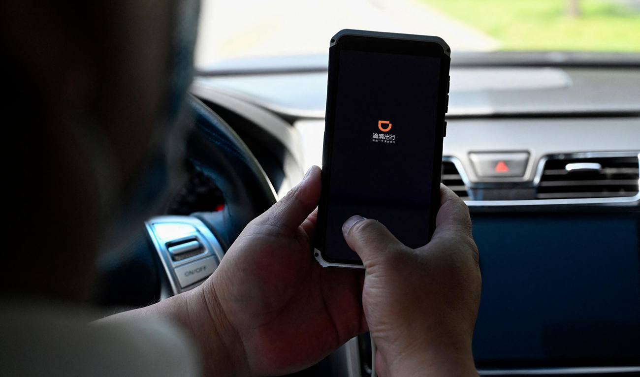 A driver opens the Didi Chuxing ride-hailing app on his smartphone in Beijing on July 2, 2021. (AFP)