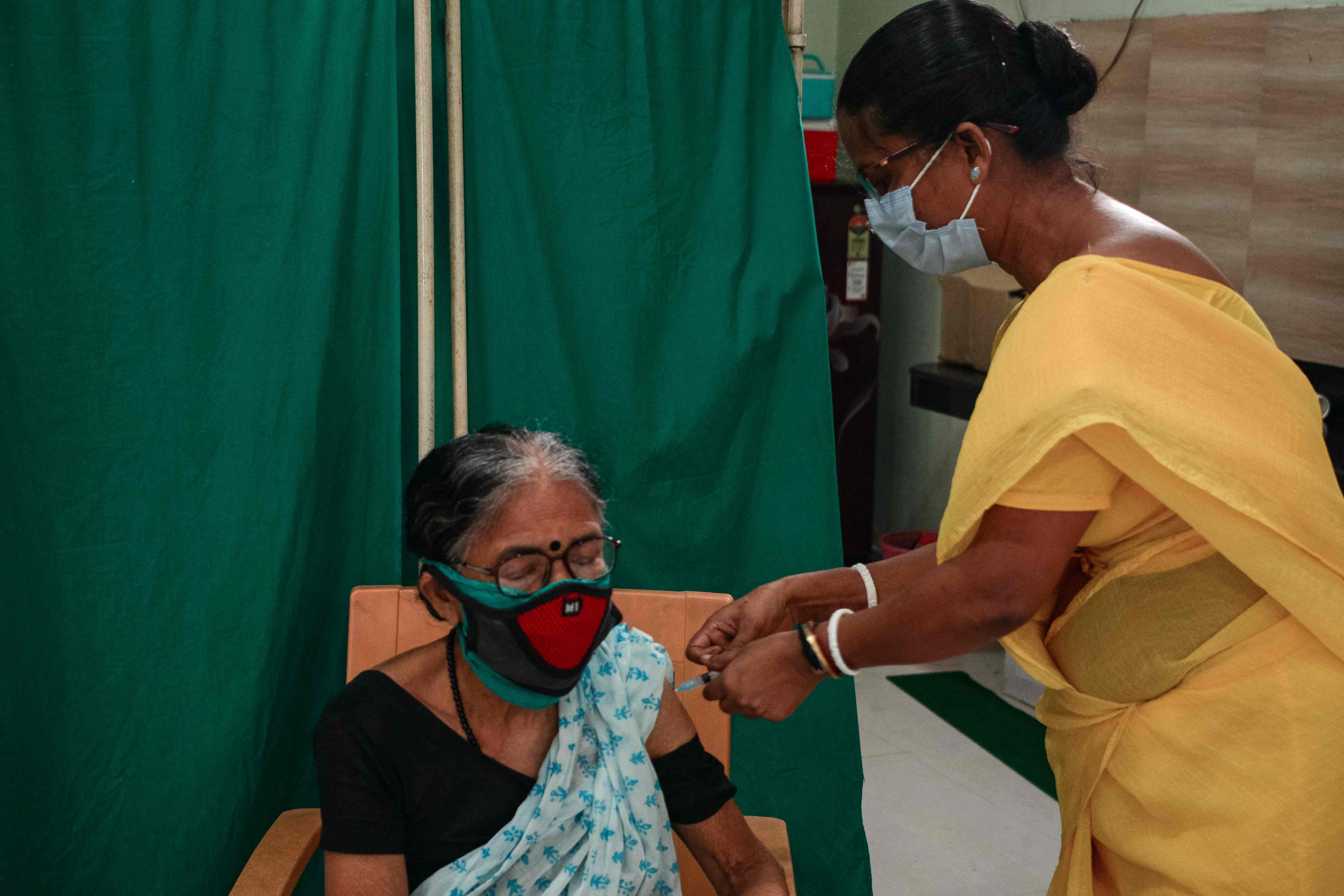 A health worker inoculates a woman with the jab of Covaxin vaccine against the Covid-19 coronavirus at a free vaccination camp in Siliguri on July 3, 2021. (AFP)