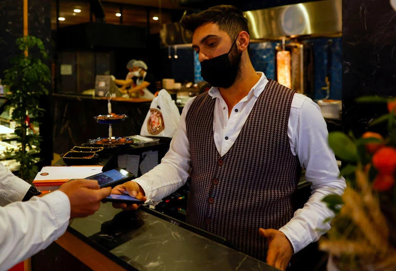 A waiter takes payment at a restaurant in Istanbul. Rising gas prices could spur inflation in the country. (Reuters)