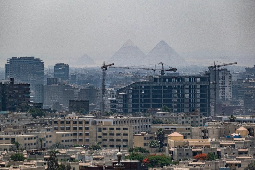 A view of the skyline of Egypt’s capital Cairo (front) and its twin city of Giza (behind), showing in the background (R to L) the Great Pyramid of Khufu (Cheops), the Pyramid of Khafra (Chephren), and the Pyramid of Menkaure (Menkheres). (File/AFP)