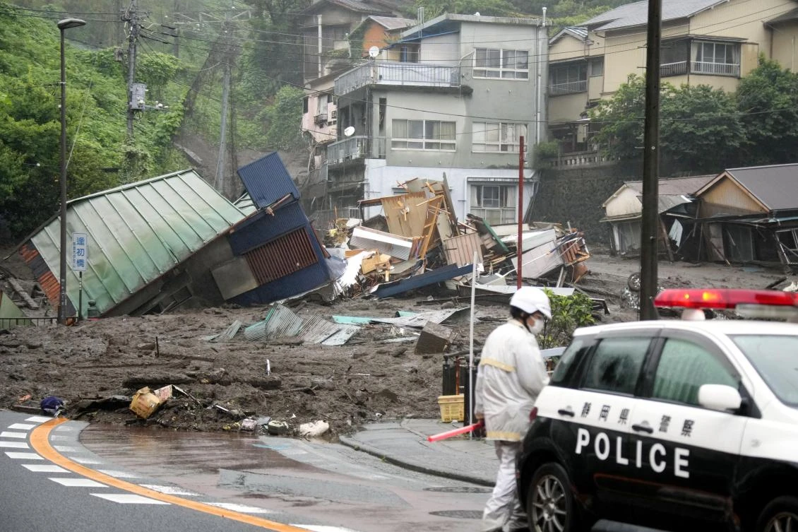 Houses are damaged by mudslide following heavy rain at Izusan district in Atami, west of Tokyo, on Saturday, July 3, 2021. (Kyodo News via AP)