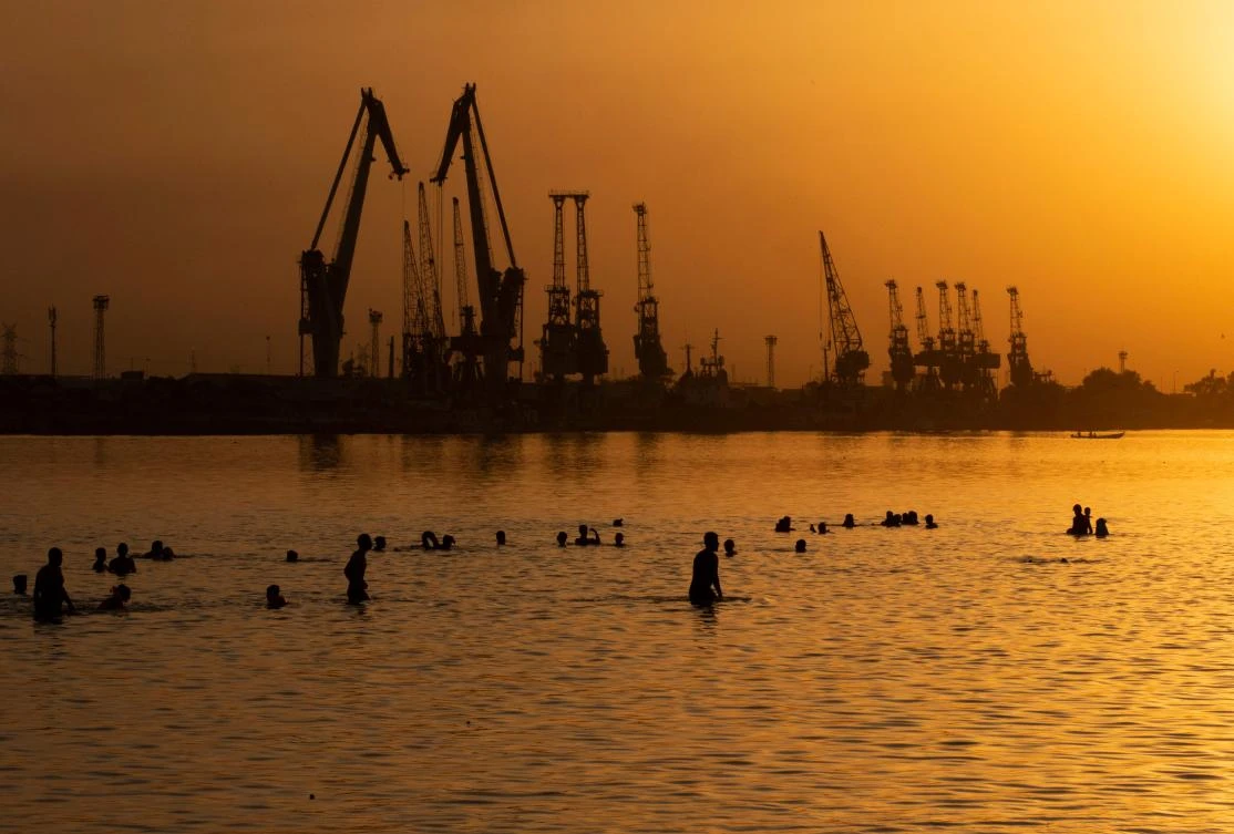 Iraqis swim in the port of Al-Maaqil in the southern city of Basra, the heartland of the country’s southern oil industry. (AFP)