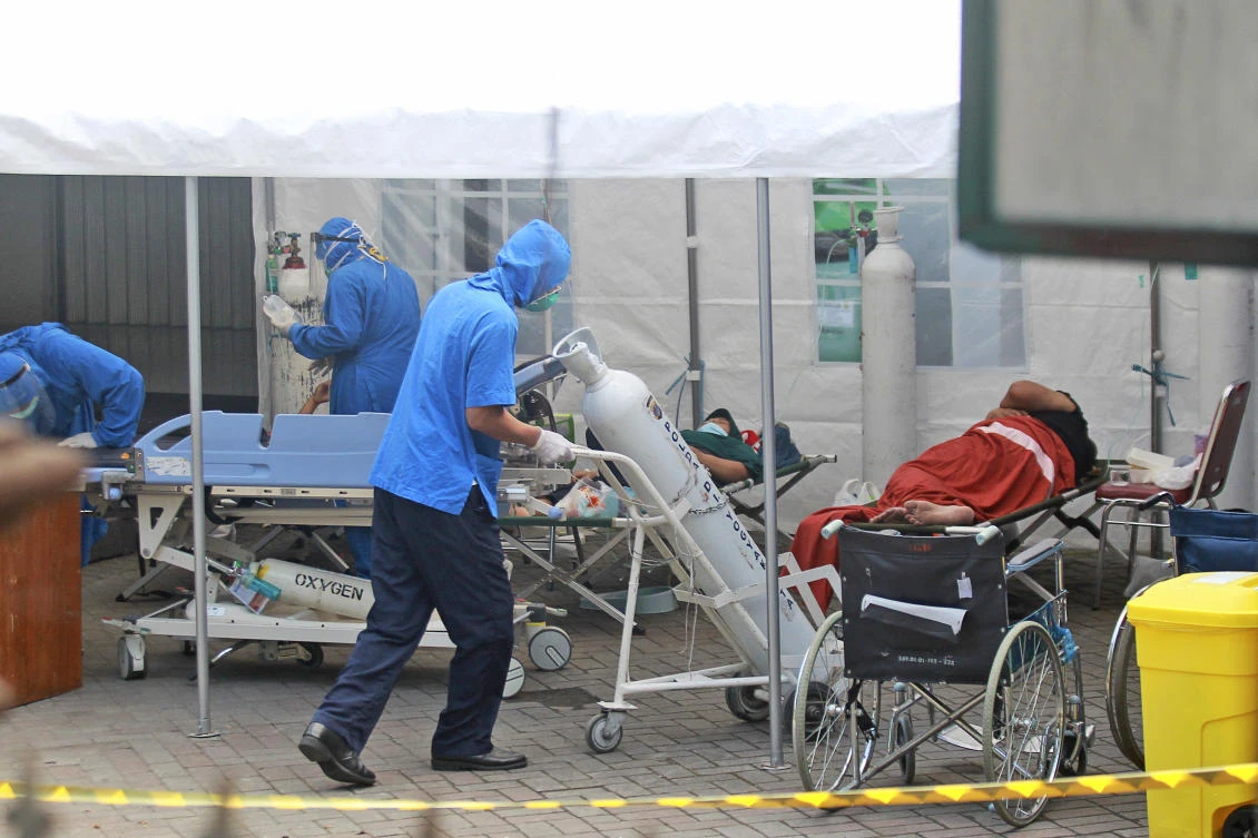 A worker wheels an oxygen tank to be used to treat patients at an emergency tent erected to accommodate a surge in COVID-19 cases at Dr. Sardjito Central Hospital in Yogyakarta, Indonesia, Sunday, July 4, 2021. (AP)