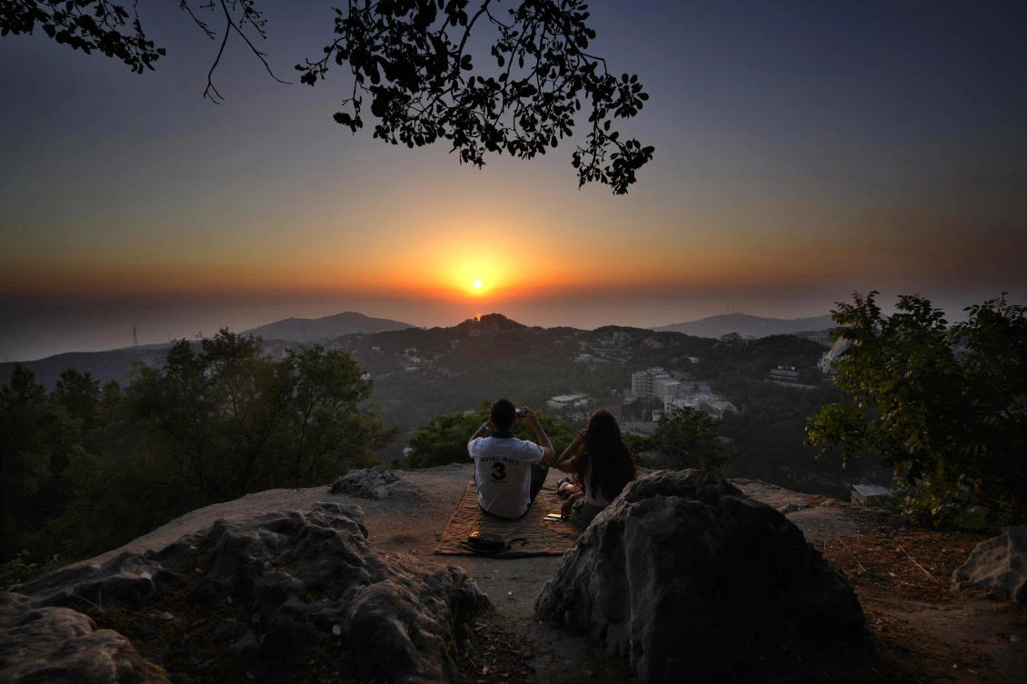 A young couple enjoy the sunset during a hike trip in Chahtoul village, in the Keserwan district, Mount Lebanon Governorate of Lebanon. (AP)