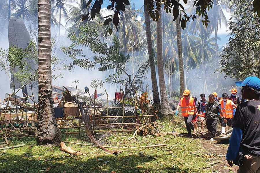 Rescuers carry a body from the site where a Philippine military C-130 plane crashed in Patikul town, Sulu province, southern Philippines on Sunday. (AP)