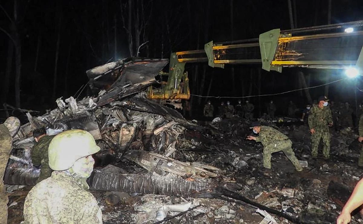 Military personnel inspect the wreckage of the ill-fated Philippine Airforce C-130 transport that crashed near the airport in Jolo town, Sulu province on July 4, 2021. (Joint Task Force-Sulu via AFP)