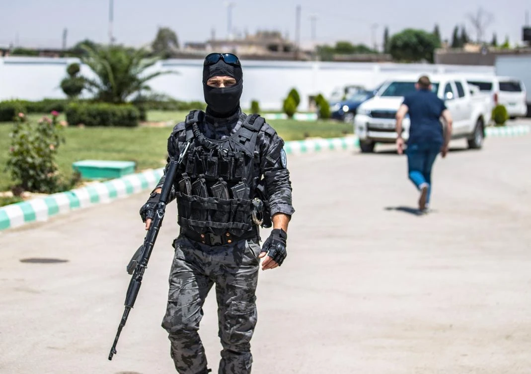 A member of Kurdish securiy forces stands guard as Syrian Kurdish authorities set out to hand over Russian orphans born to parents linked to Daesh to a Russian delegation for repatriation in Qamishli. (AFP)