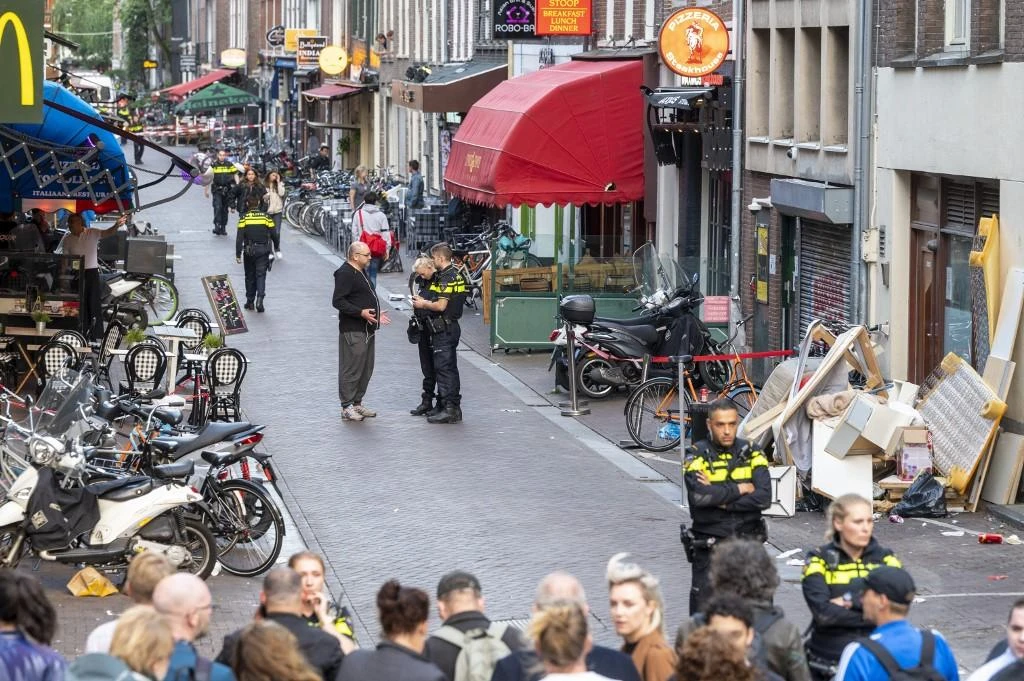 Police officers investigate the site of an attack where a Dutch journalist, Peter R. de Vries was seriously injured in a shooting in Amsterdam. (AFP)