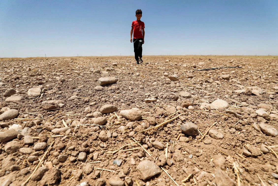 A boy walks through a dried up agricultural field in the Saadiya area, north of Diyala in eastern Iraq. (AFP)