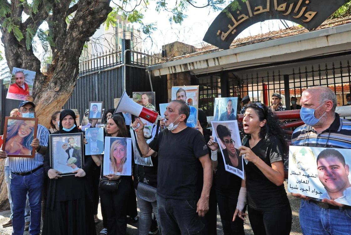Relatives of the Beirut’s blast victims demonstrate and shout slogans while lifting portraits of their deceased during a protest on Friday following a judge’s decision to pursue senior political and security figures in the case. (AFP)