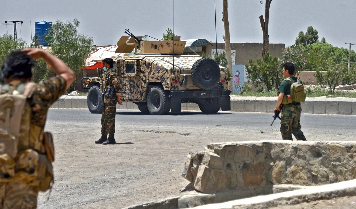 Afghan security personnel stand guard along the road amid ongoing fight between Afghan security forces and Taliban fighters in Kandahar on July 9, 2021. (AFP)