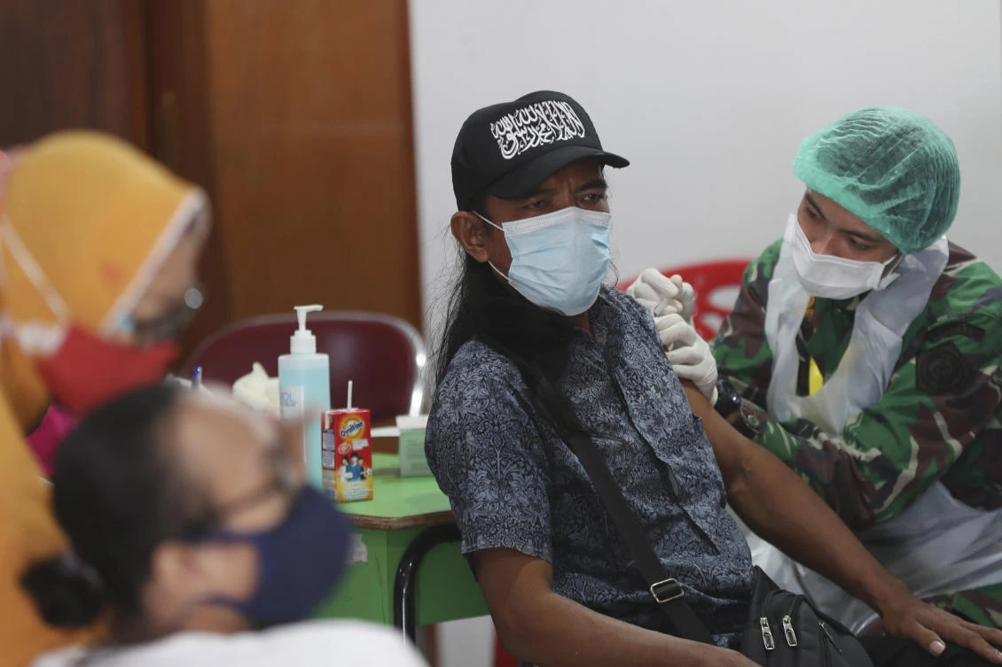 A man receives a shot during a vaccination campaign in Jakarta. Rising infection rates worldwide are weighing on oil price sentiment. (AP)