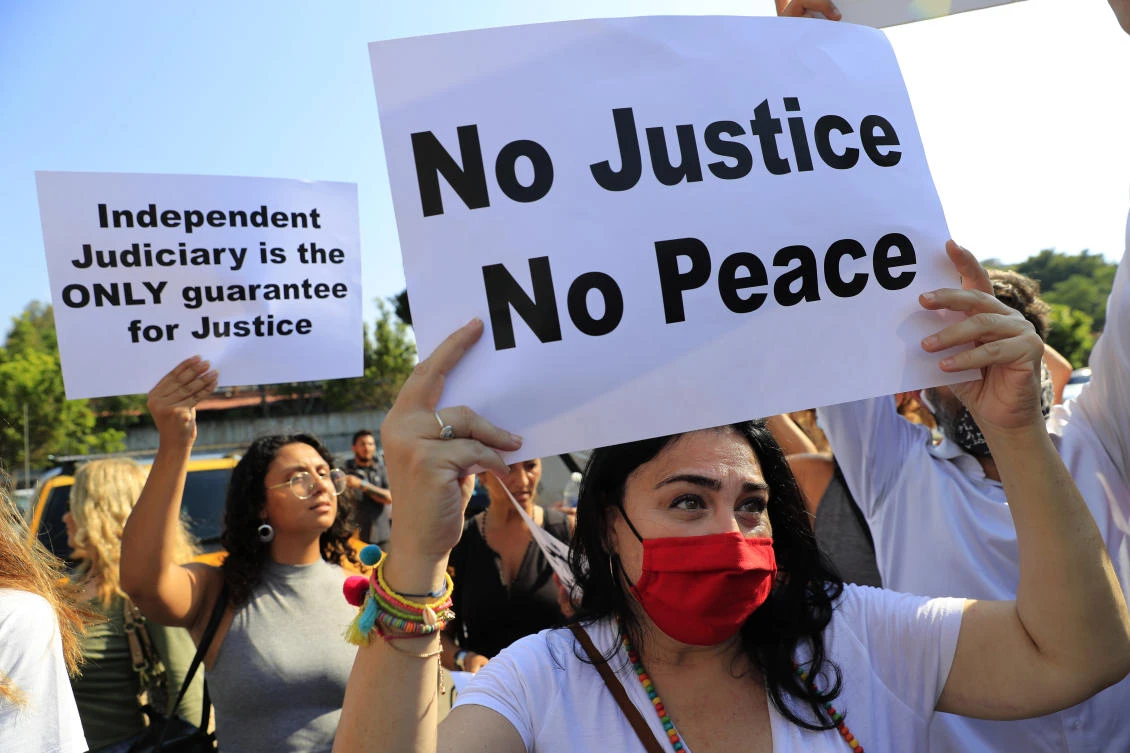 Supporters of families killed in 2020’s massive blast at Beirut’s seaport hold a placard during a protest in support of legal action on Monday. Judge Tarek Bitar to pursue politicians and security chiefs in the case. (AP)