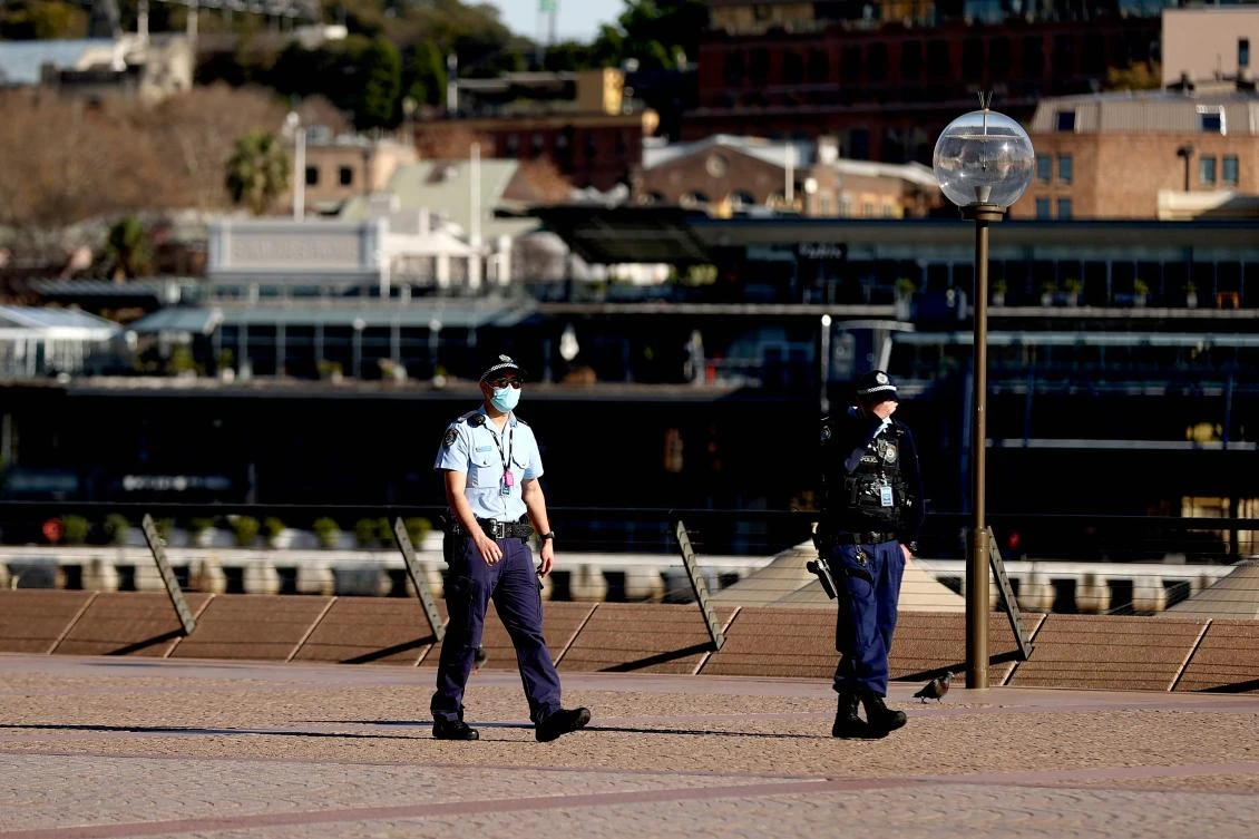This picture taken on July 13, 2021 shows police officers patrolling around the Opera House, as Sydney's five million residents will be in Covid-19 lockdown for "at least" another two weeks. (AFP)