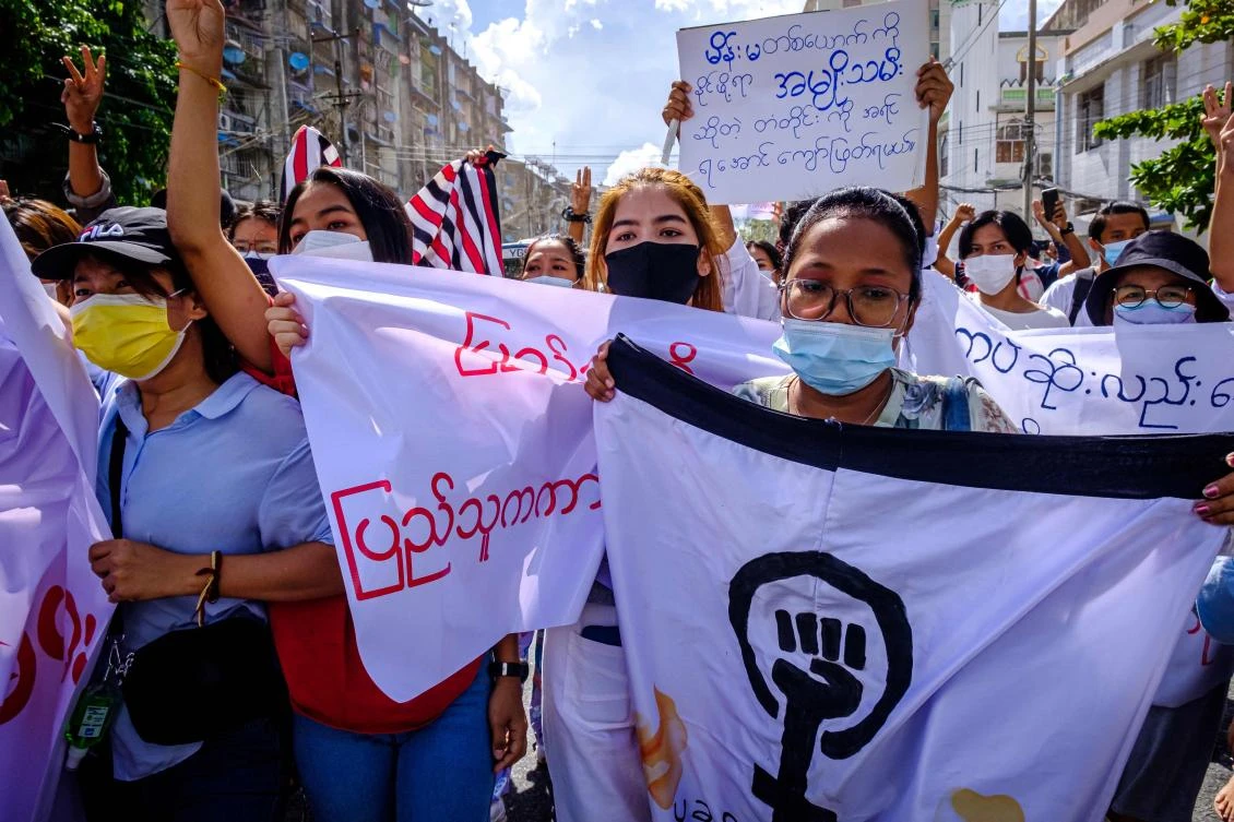 Women carry banners as they march during a demonstration against the military coup in Yangon on July 14, 2021. (AFP)