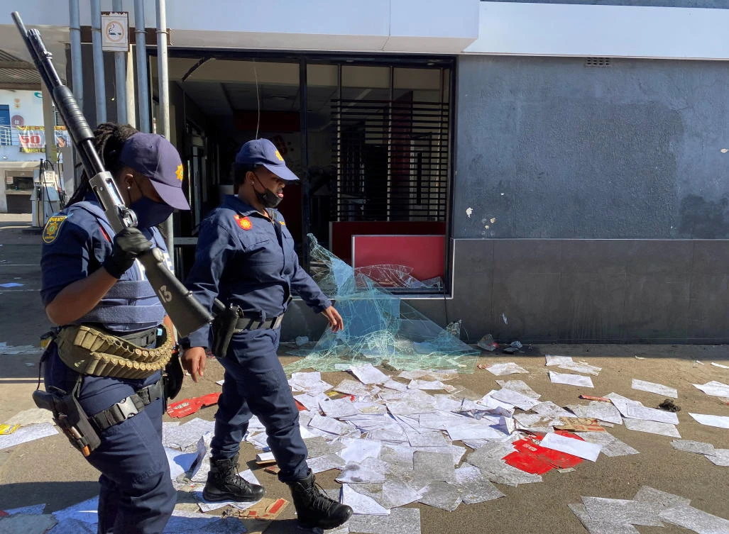 Police walk past a shop looted in protests following the jailing of former South African President Jacob Zuma, in Durban. (Reuters)