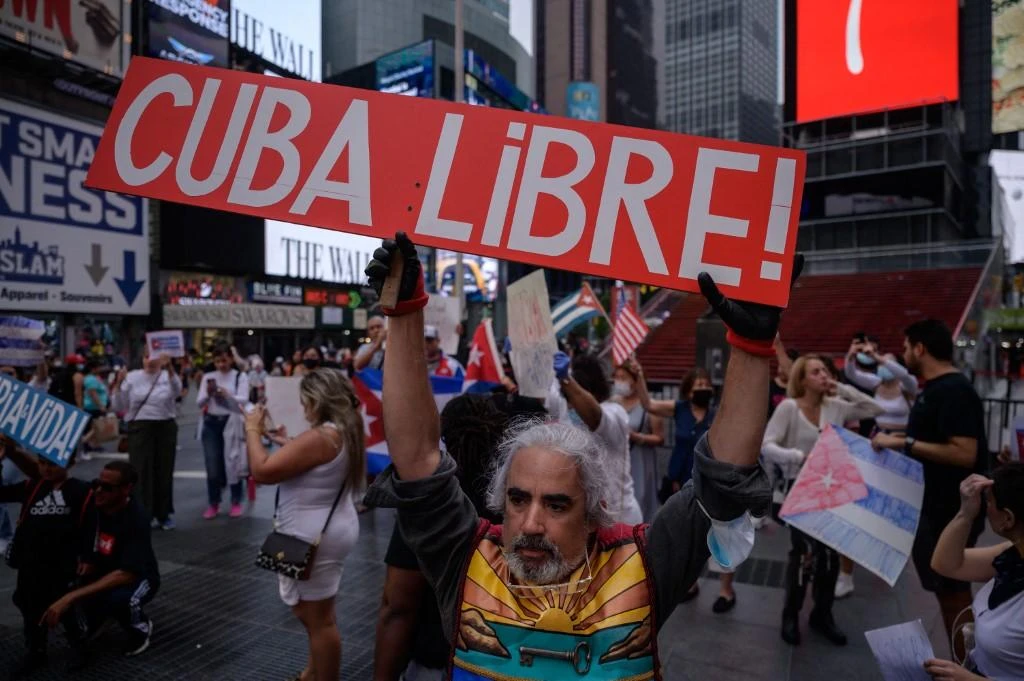 Demonstrators hold placards during a rally held in solidarity with anti-government protests in Cuba. (AFP)