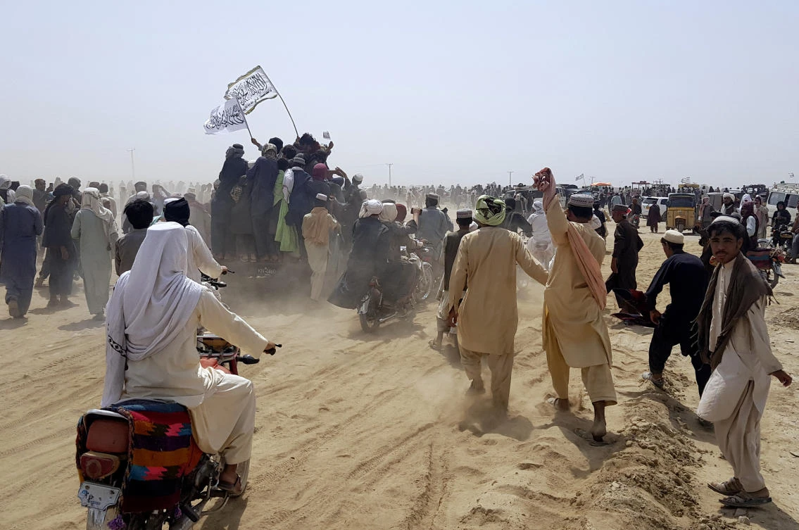 Supporters of the Taliban carry the Taliban's signature white flags in the Afghan-Pakistan border town of Chaman, Pakistan, Wednesday, July 14, 2021. (AP)