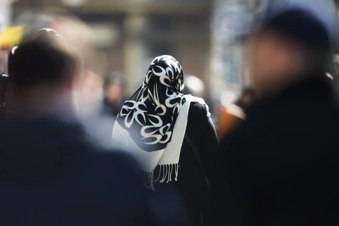 In this March 15, 2013 file photo a woman with a headscarf, a traditional dress for Islamic women, walks between other people on a street at the district Neukoelln in Berlin. (File/AP)
