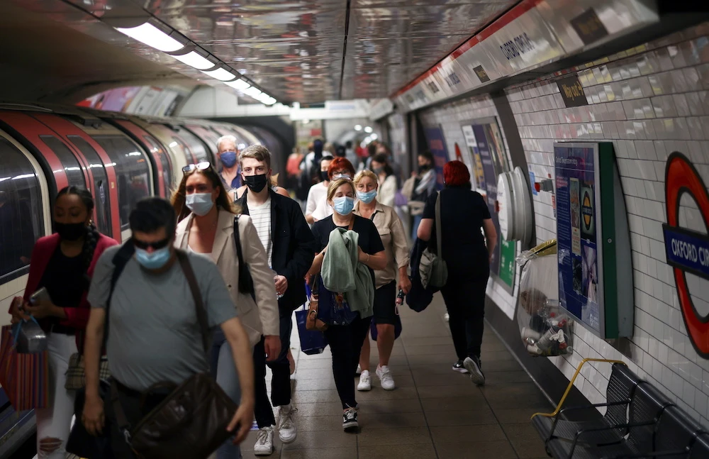 People, some wearing protective face masks, walk along a platform at Oxford Circus underground station, amid the coronavirus disease (COVID-19) pandemic, in London, Britain, July 4, 2021. (Reuters)