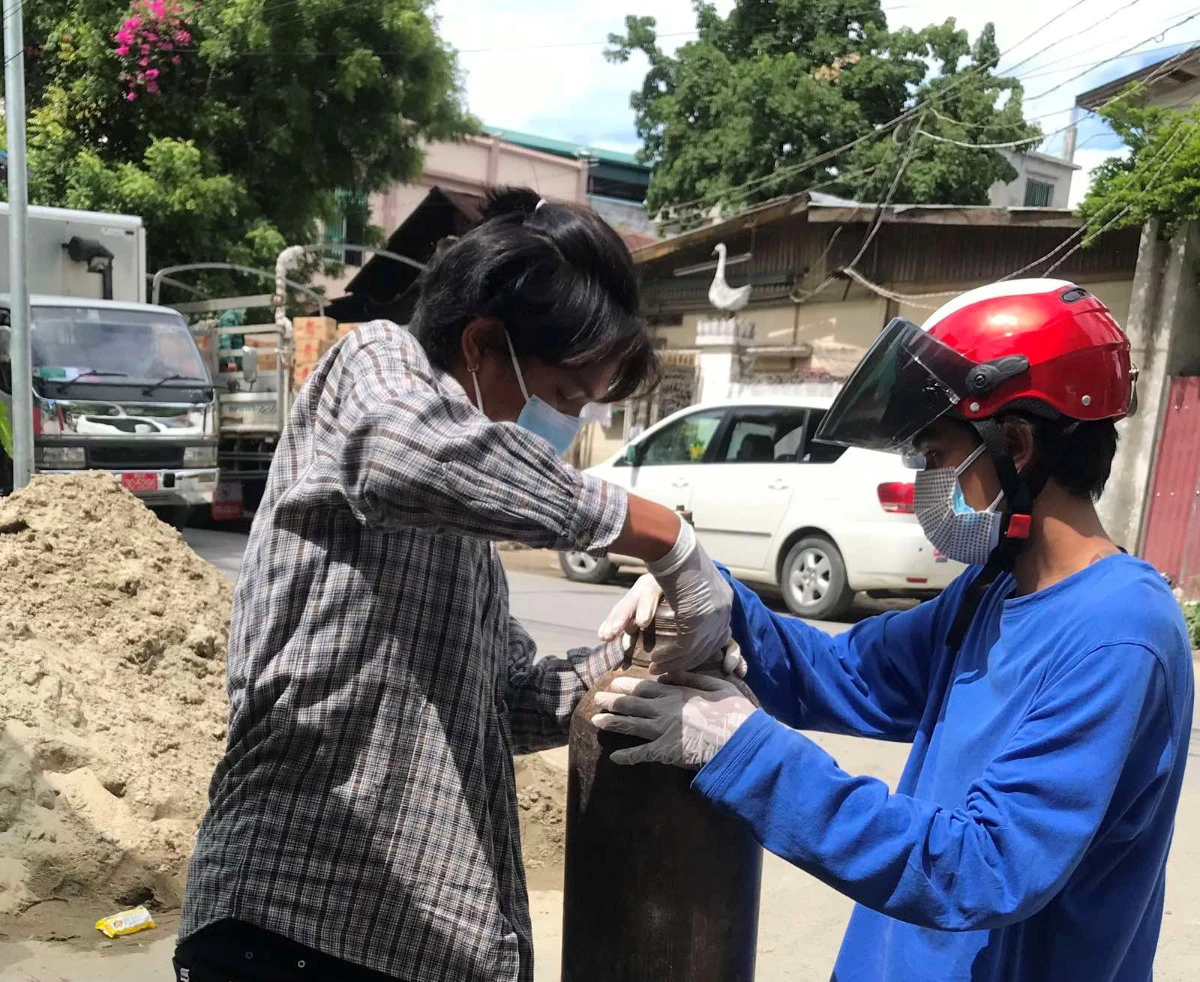 A volunteer fills an oxygen tank as COVID-19 cases surge in Mandalay, Myanmar, on July 13, 2021. (Phoe Thar via REUTERS)