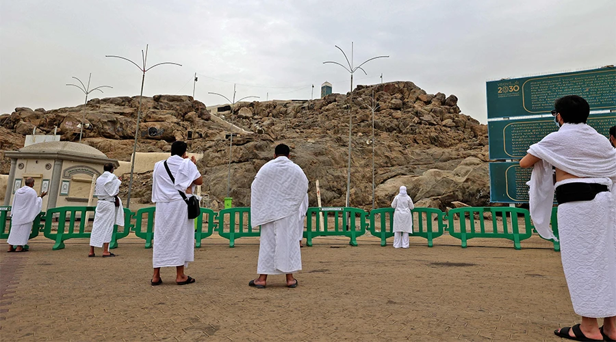 Muslim pilgrims pray next to Saudi Arabia's Mount Arafat southeast of the holy city of Mecca, during the climax of the Hajj pilgrimage on July 19, 2021. (AFP)