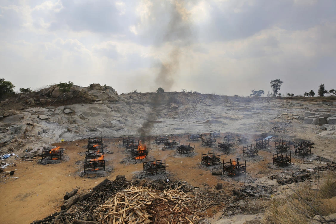 Daily coronavirus-related deaths in India jumped to 3,998, their highest since June 12. Above, funeral pyres of COVID-19 fatalities burn at an open crematorium set up at a granite quarry on the outskirts of Bengaluru. (AP)