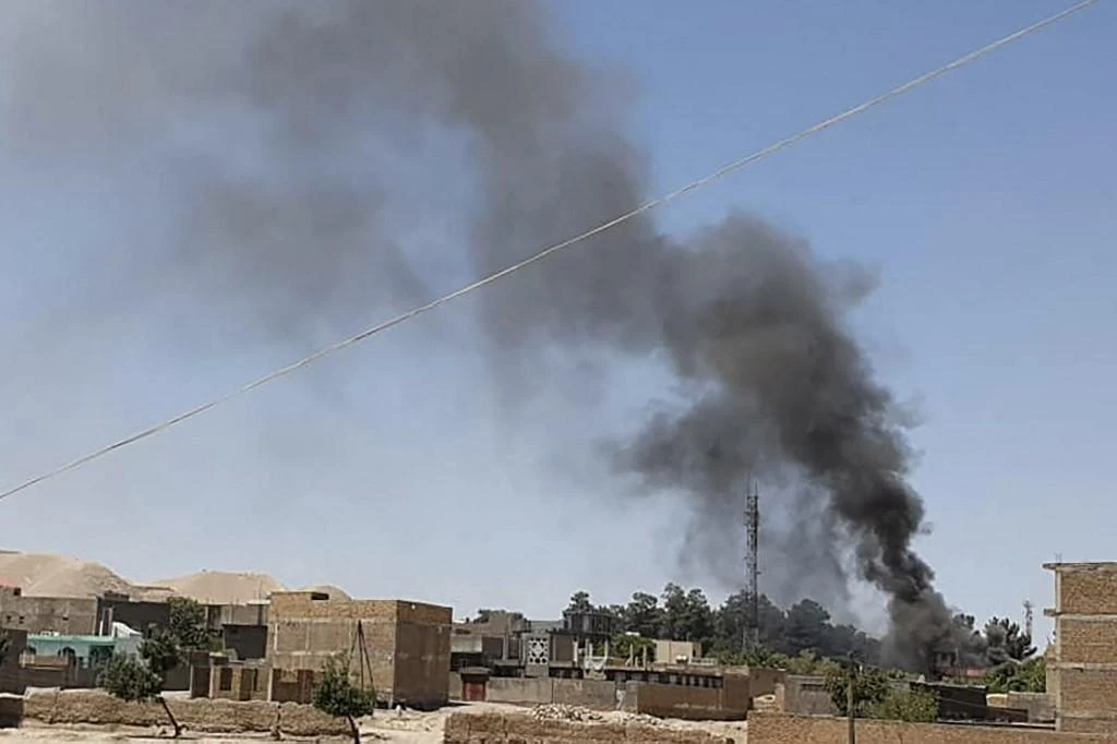 A smoke plume rises from houses amid ongoing fight between Afghan security forces and Taliban fighters in Badghis province on July 7, 2021. (AFP)