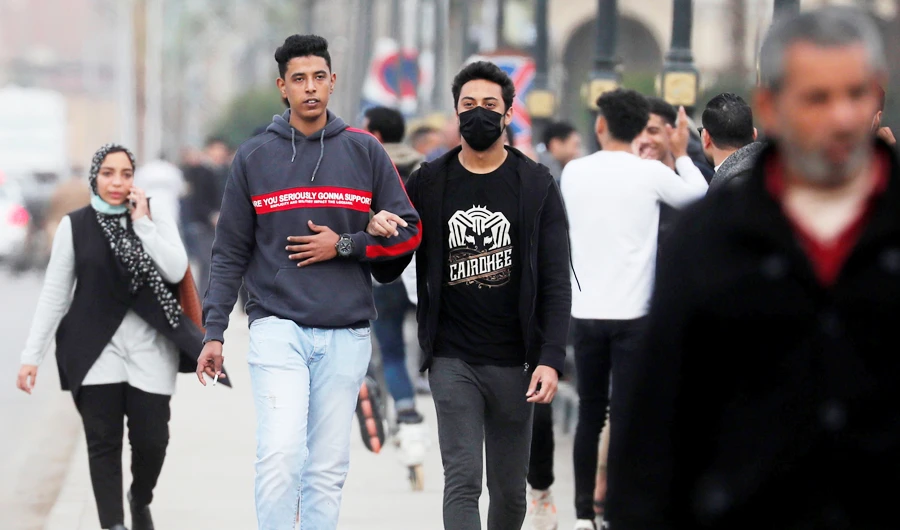 People, some of them wearing protective face masks amid the coronavirus disease (COVID-19) pandemic, walk on Qasr el-Nil bridge leading to Cairo's Tahrir Square, Egypt. (REUTERS file photo)