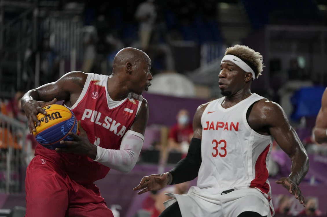 Poland’s Michael Hicks looks to pass around Japan’s Ira Brown (33) during a men’s 3-on-3 basketball game at the 2020 Summer Olympics Saturday. (AP)