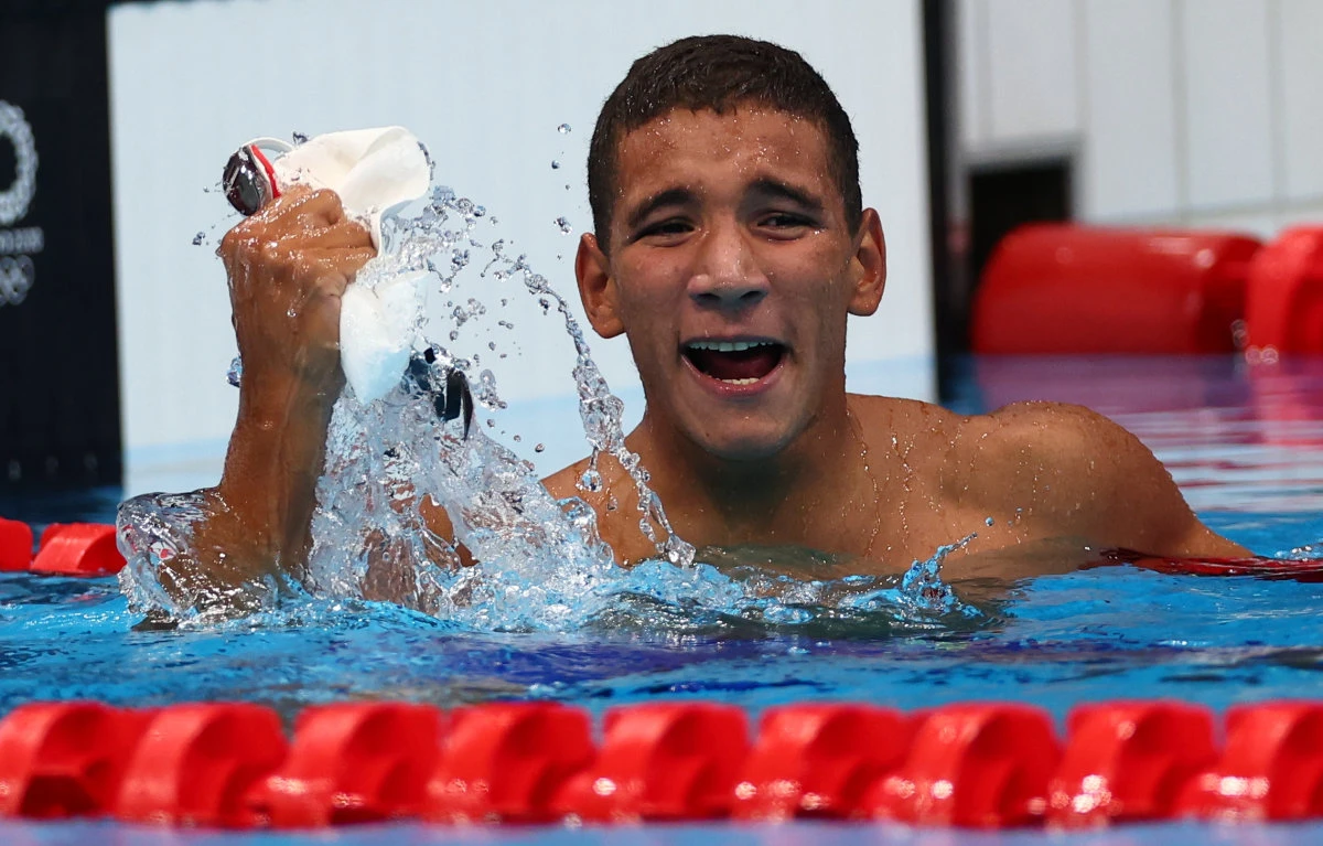 Tunisian swimmer Ahmed Hafnaoui celebrates after winning the gold medal in the Men's 400m Freestyle. (REUTERS/Kai Pfaffenbach)