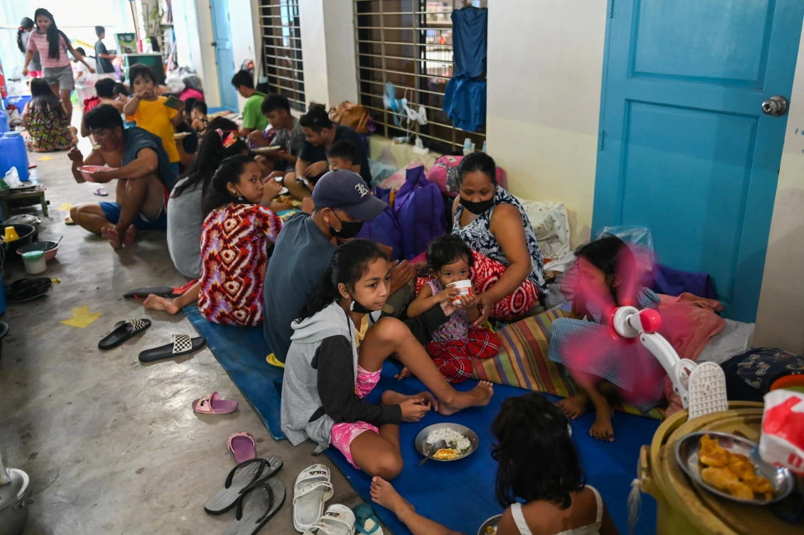 Residents have a meal after being evacuated at a school amid heavy rains that caused flooding in some areas in Marikina city, Metro Manila, Philippines, July 24, 2021. (Reuters)