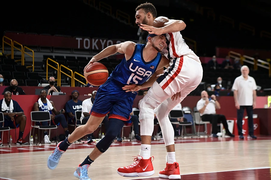 USA's Jayson Tatum dribbles the ball past France's Rudy Gobert (R) during the men's preliminary round group A basketball match between France and USA during the Tokyo 2020 Olympic Games in Saitama on July 25, 2021. (AFP)