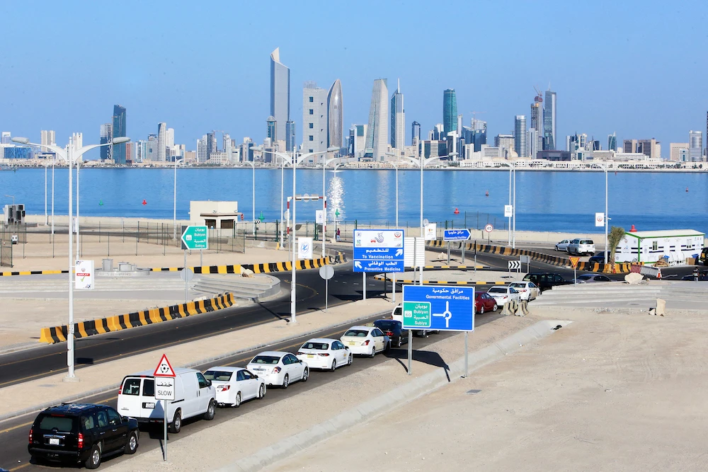 Kuwaitis queue in their cars to receive a dose of a COVID-19 vaccine at a drive-thru inoculation site at the Jaber Al-Ahmad Al-Sabah causeway in the capital Kuwait City. (File/AFP)