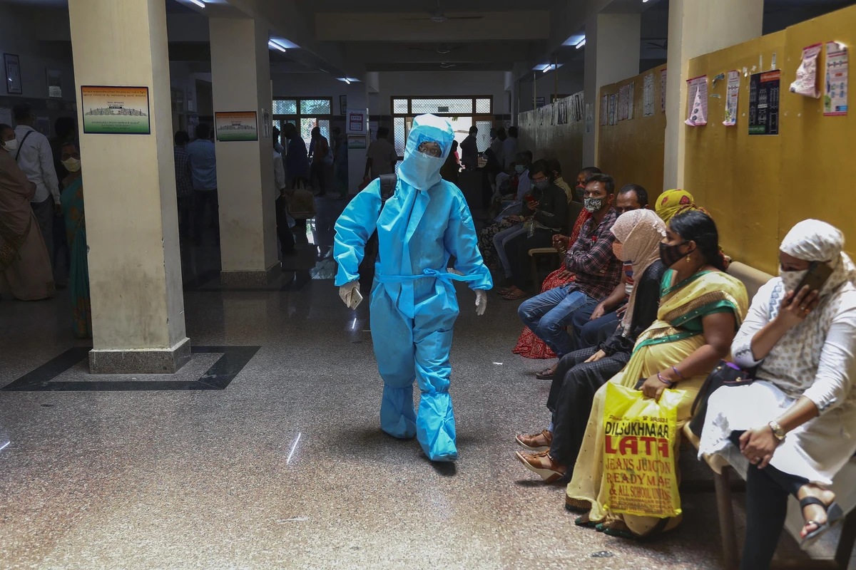 An Indian woman in personal protective suit walks towards a COVID-19 ward of a hospital as others waits for their test results in Hyderabad, India, Thursday, April 29, 2021. (AP)